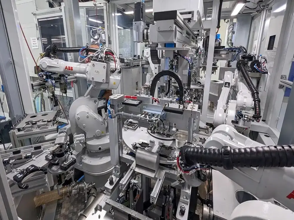 Overview of a highly complex, automated manufacturing cell with multiple ABB industrial robots, linking systems, and feeding units for custom machine building at AWM Arnstadt.