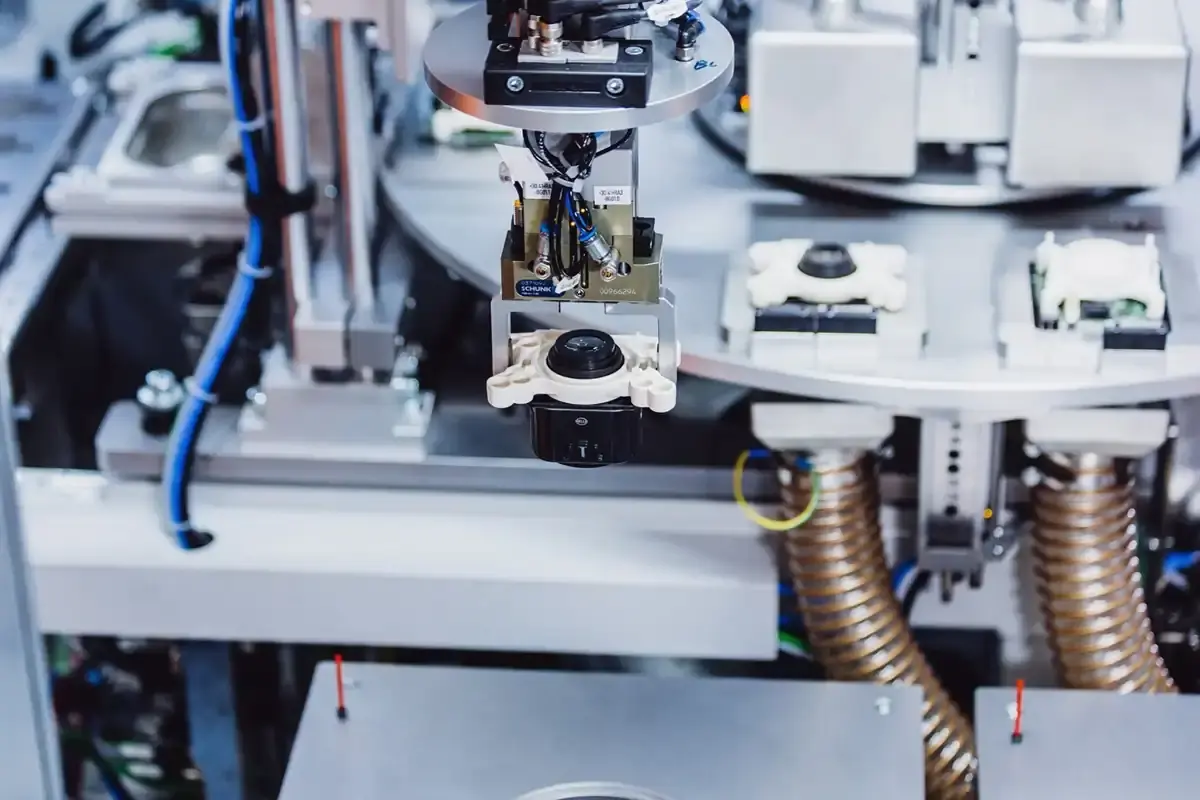 Precision gripper system on a fully automated AWM assembly line positioning and joining LED headlight modules for the automotive industry.