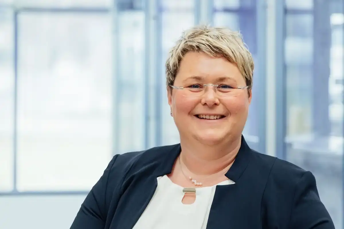 Portrait shot of Annette Bezold, executive at AWM Arnstadt, set against a modern, bright office backdrop.